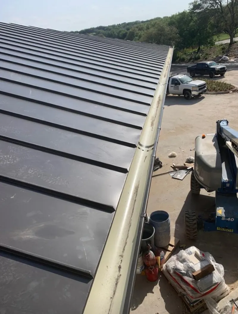 Standing seam panel and gutter detail on a metal roofing jobsite in Harper Woods